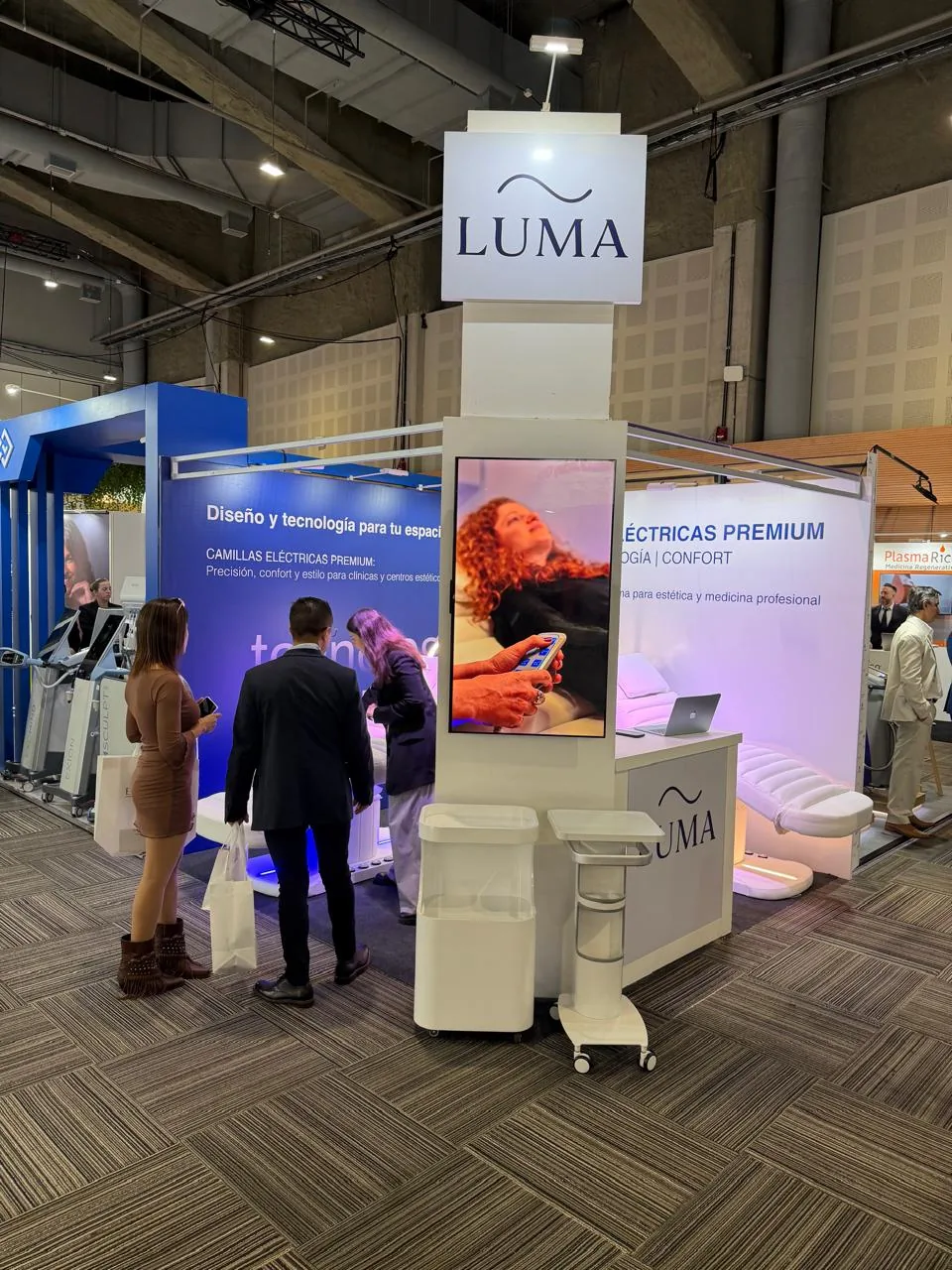 Stand de LUMA en el BAAS International Congress con visitantes consultando frente a la pantalla de producto.