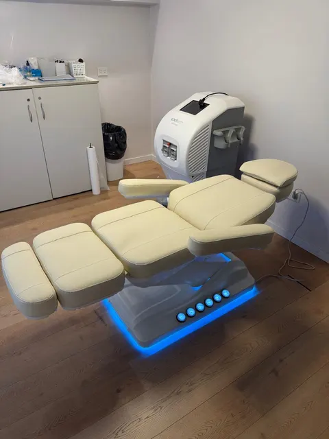 Camilla LUMA One beige con luz LED azul en la base, en un consultorio de estética.