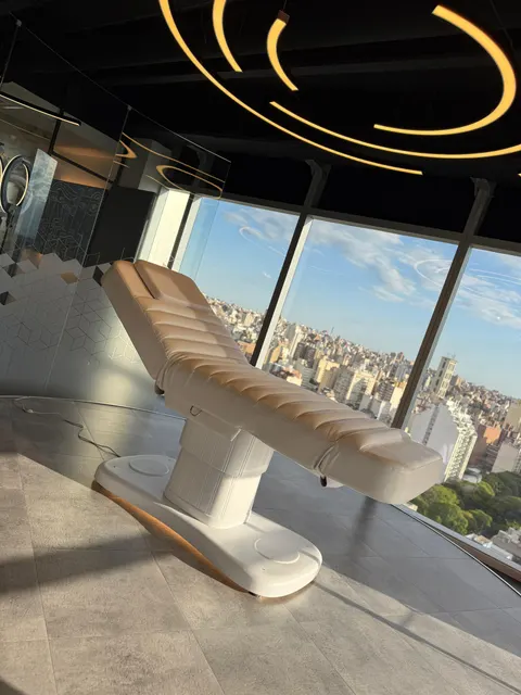 Camilla LUMA Premium beige en un consultorio en altura con ventanales y vista a la ciudad.